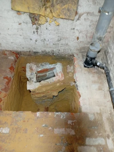 Uitgraven en blootleggen van een oude defecte gemetselde rioolput in Schaarbeek door aannemer Elsa Bouw